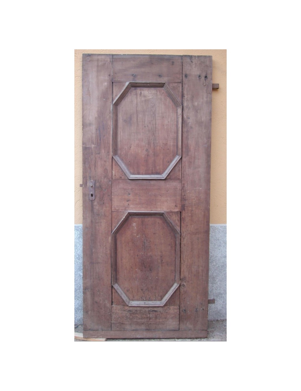 Porta in noce a un battente a due specchiature ottagonali Porta in noce a un battente a due specchiature ottagonali