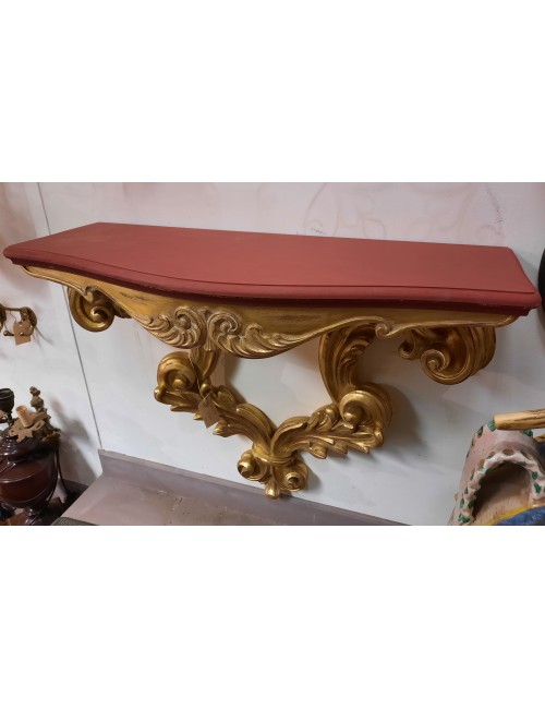 Consolle moderna con piano rosso e gambe foglia oro