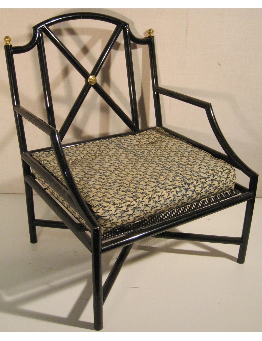 Poltrona in ferro laccato, sedile imbottito, decori in ottone. Modello riproducibile